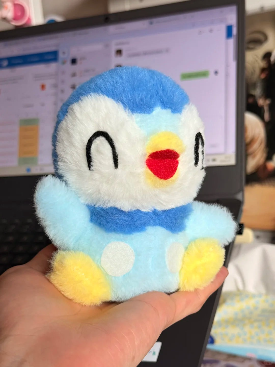 Hand-held handmade Piplup plush with fluffy blue fabric and embroidered smiling eyes