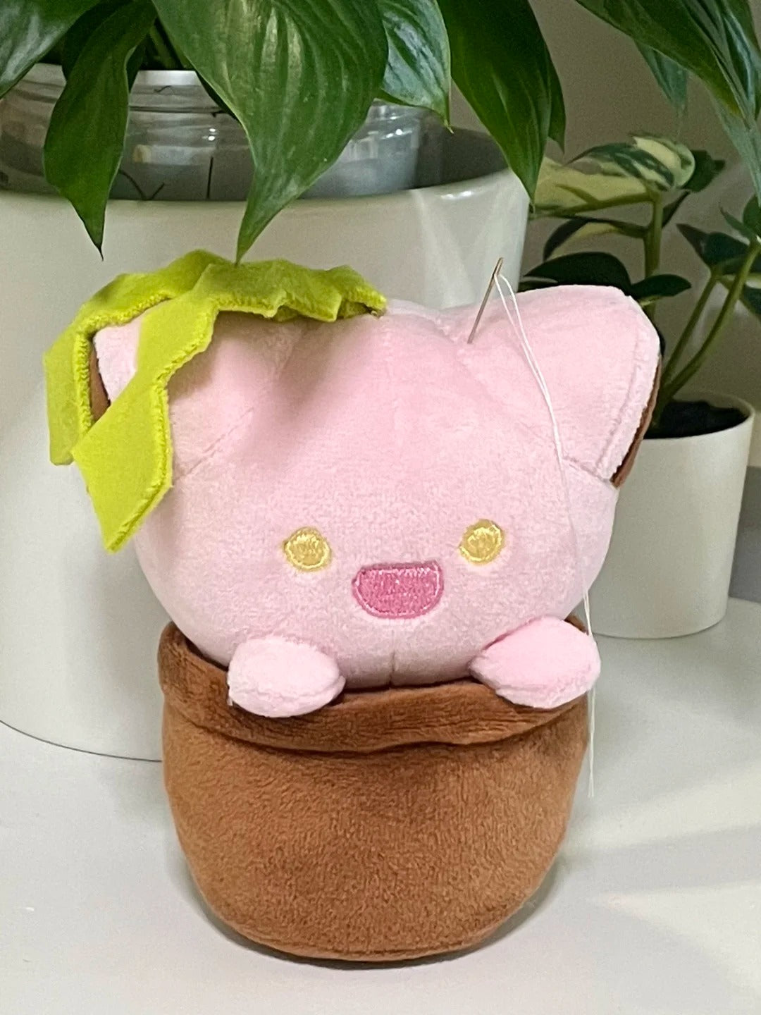 Front view of a pink cat plant plush with green felt leaves in a brown flowerpot