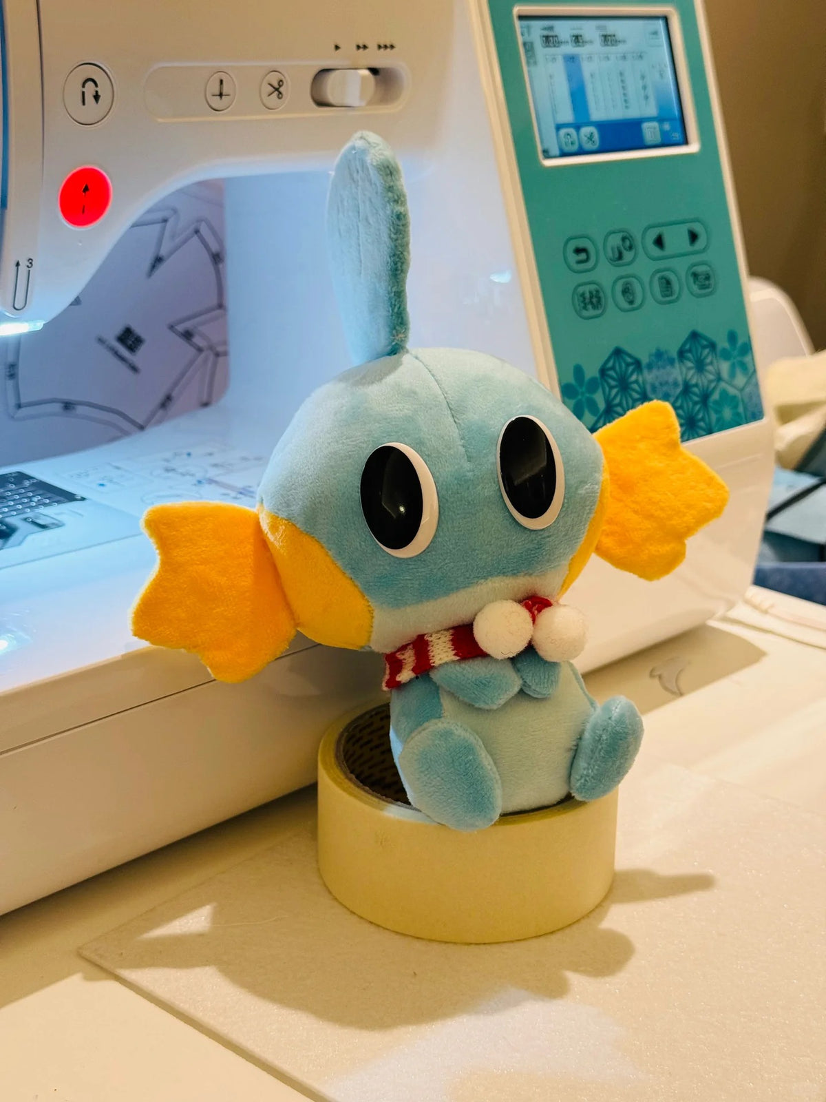 Handmade Mudkip plush beside sewing machine – Pokémon DIY project sewing inspiration