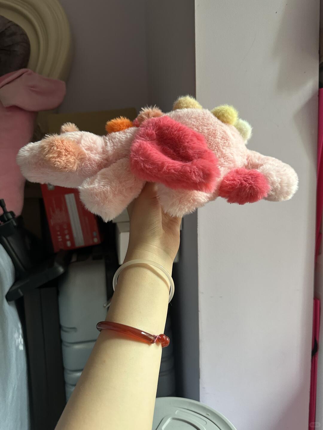 Handmade pink Sky Dragon plush sewing pattern sample held sideways in natural light