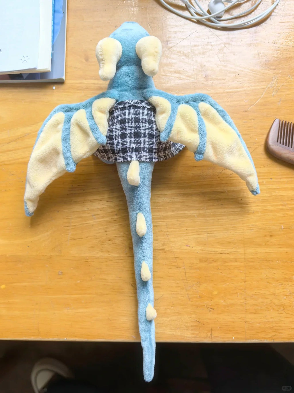 Back view of a blue and cream posable winged dragon plush with long tail and fabric wings