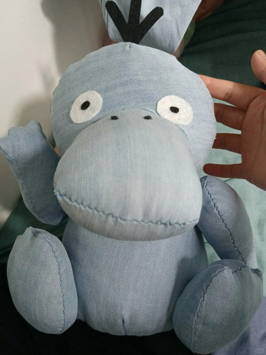 Close-up of a soft blue-gray Psyduck-inspired plush