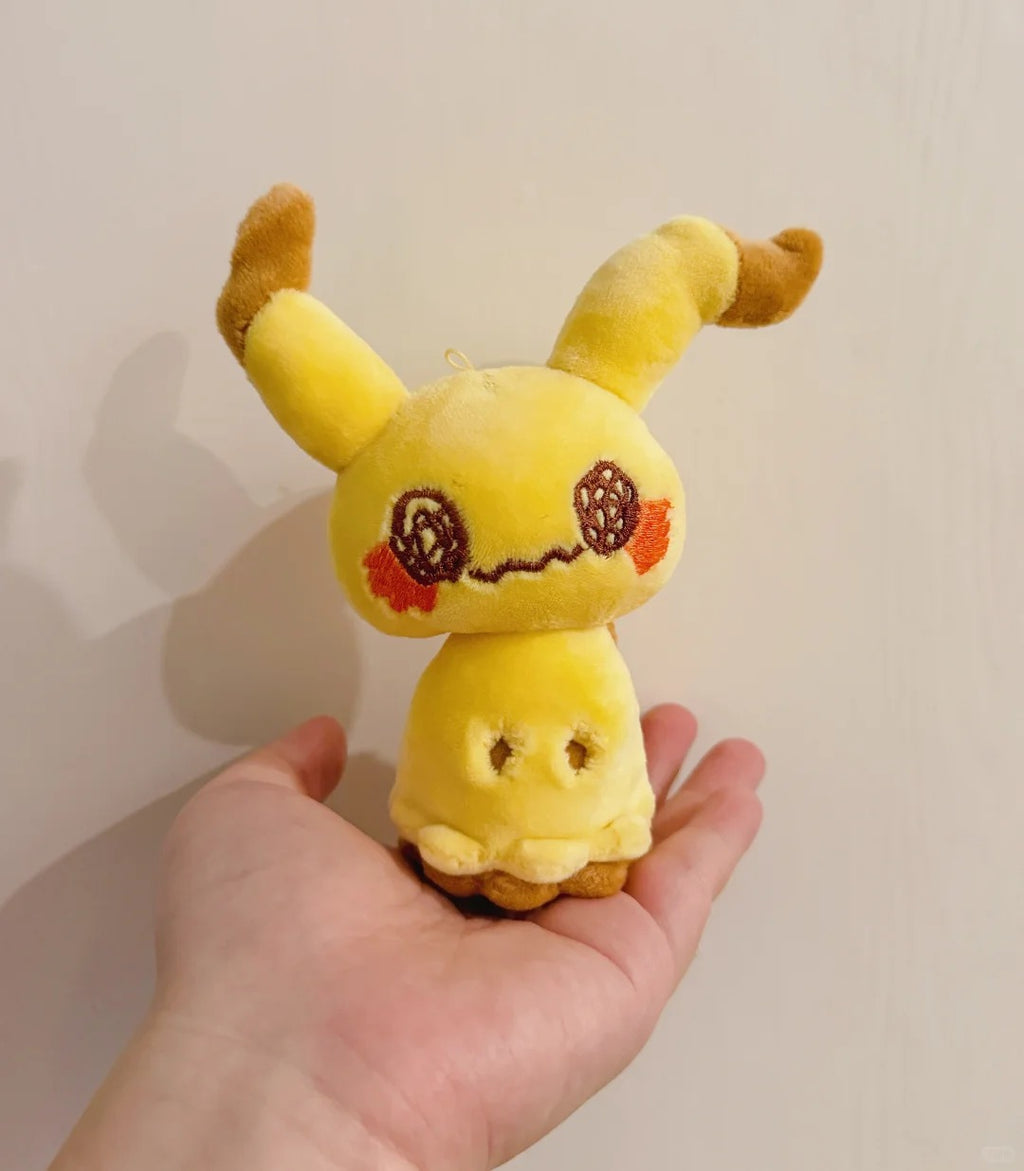 Front view of a handmade standing Mimikyu plush doll held in one hand