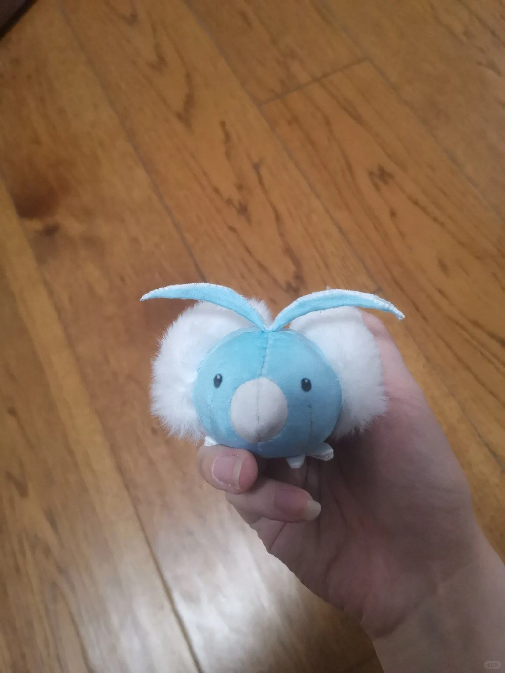 Close-up front view of a blue Swablu plush showing its beak and head feathers