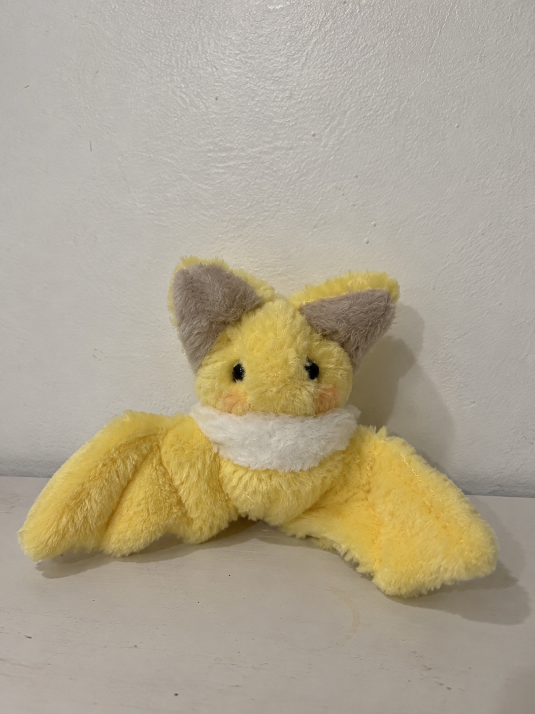 Handmade yellow bat plush sewing pattern finished example on a tabletop